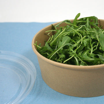 Ciotola di cartone avana con coperchio vicino piena di rucola